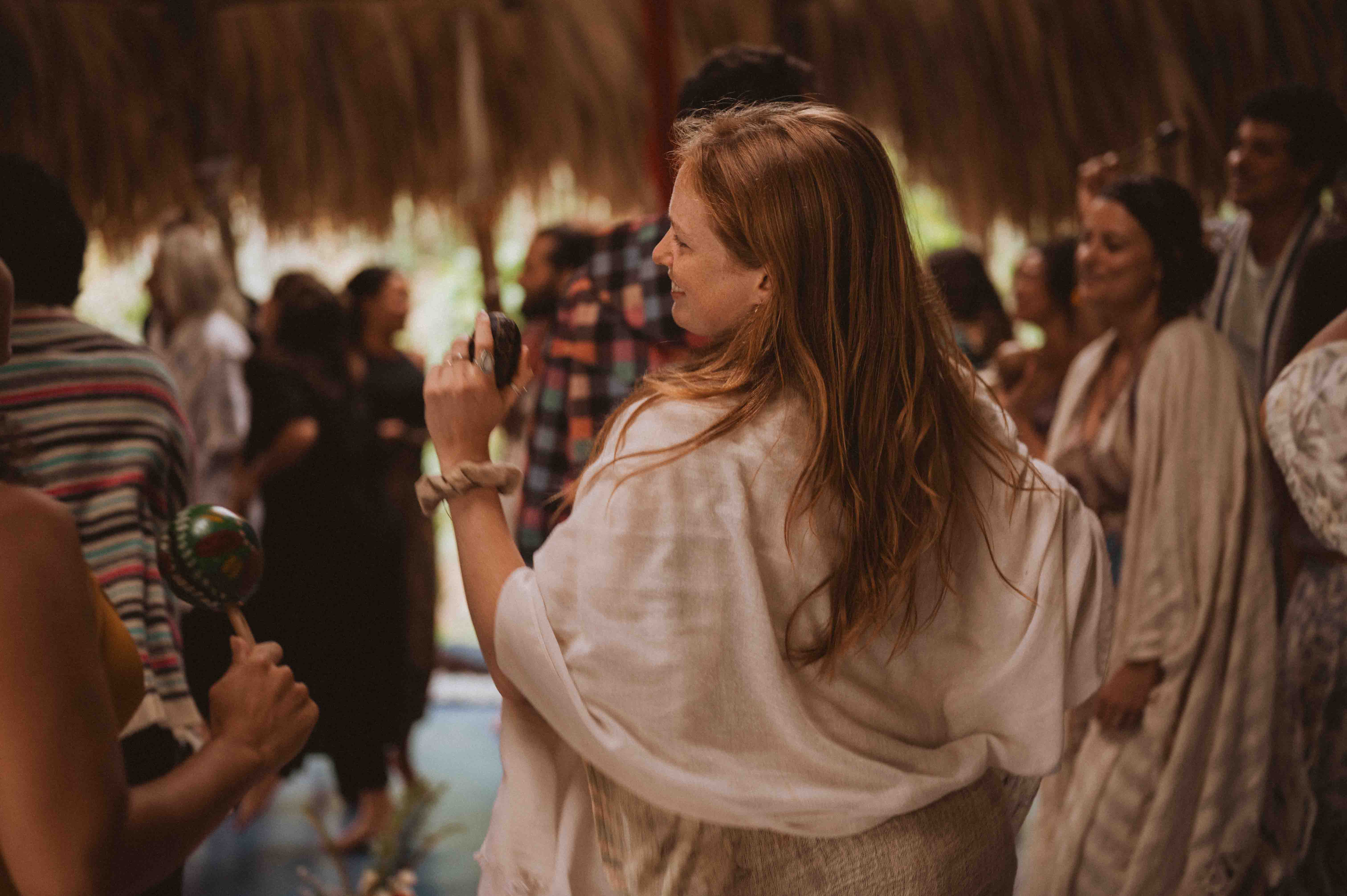 A guest plays a shaker during a HeartSong music circle